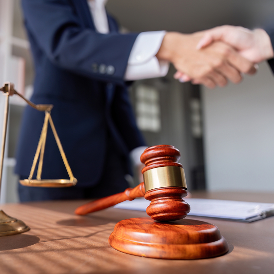 Lawyer and judge shaking hands over a table with a gavel