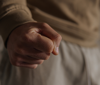 A man's hand is shown holding a clenched fist
